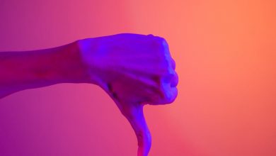 A thumbs down over a magenta background