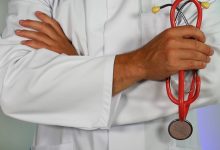 A doctor stands with his arms crossed.